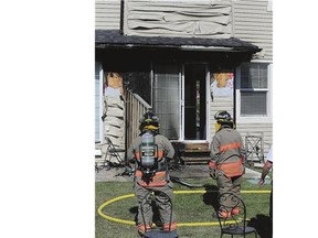 Firefighters survey the damage after a blaze Friday on Ledingham Way.