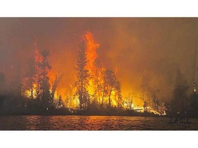 The flames of the Eli fire are seen on the shores of Lac la Ronge on Friday.