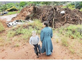 A flash flood leaves a destroyed car and other debris in its wake Tuesday in Colorado City, Ariz.