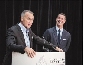 Former NHL star Paul Coffey, left, with presenter Mark Tewksbury, addresses the media in Toronto after being formally inducted into the Canadian Sports Hall of Fame on Wednesday.