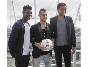 From left: Canadian men's national soccer team players Sam Adekugbe, Russell Teibert and Caleb Clarke, who all play for the Vancouver Whitecaps MLS team, pose on a balcony overlooking BC Place stadium after a news conference in Vancouver on Monday. The Canadian Soccer Association announced that the Canadian men's national soccer team will play Honduras in a 2018 FIFA World Cup qualifier in Vancouver on Nov. 13.