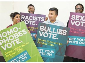 From left, Sara Kamyav, Sylvester Nartehyoe, Graham Pedregosa, and Elton Afriyie hold signs that will be posted up around Carleton University campus urging students to vote.