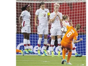 From left: Team Canada's Karina LeBlanc, Christine Sinclair and Sophie Schmidt form a wall to defend a shot from the Netherlands' Sherida Spitse in the Women's World Cup.