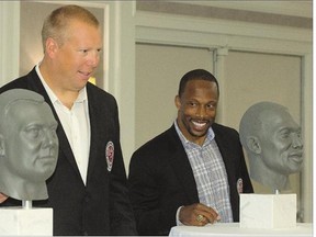 Gene Makowsky, left, and Eddie Davis, unveil their busts for the Canadian Football Hall of Fame during a ceremony in Saskatoon on Thursday.