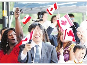 A group of new Canadians waves flags after taking the oath of citizenship and receiving their citizenship certificates at Queen's Park in Toronto. Party leaders have differing views on the meaning of citizenship and the issue has emerged as a major theme of the federal election.