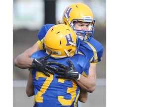 The Hilltops’ Evan Kopchynski and Davis Mitchell celebrate a touchdown during first half action of the league final against the Calgary Colts at SMF Field in Saskatoon on Oct. 26, 2014.