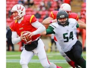 The Huskies’ Evan Machbroda (No. 54) chases Dinos quarterback Andrew Buckley.