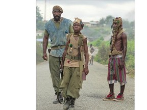Idris Elba, left, as Commandant, and Abraham Attah, centre, as Agu, star in the Netflix original film, Beasts of No Nation, directed by Cary Fukunaga. The film explores the tragedy of Africa's child soldiers.