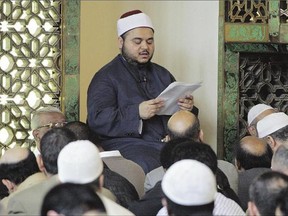 An imam reads a sermon to Muslims gathered in London's central mosque for the Friday prayers.