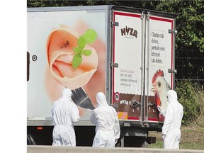 Investigators stand near a truck in which up to 50 dead migrants were found, about 40 kilometres east of Vienna, near the town of Parndorf, on Thursday.