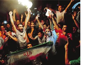 Iranians cheer in the streets of Tehran following a landmark nuclear deal signed in Vienna, Tuesday. After long, fractious negotiations, the agreement curbs Iran's nuclear program in exchange for billions of dollars in relief from international sanctions.