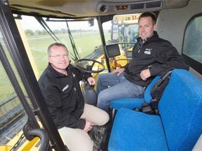 James Schultz and Rick Rivett, left, of Moody’s Equipment pose with a New Holland combine and a GPS display, Tuesday, September 15, 2015, for story on agriculture technology.