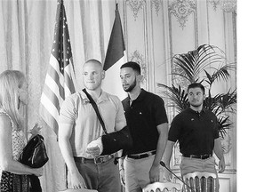 Jane D. Hartley, U.S. Ambassador to France, left, meets with, from second left, Spencer Stone, Anthony Sadler, and Alek Skarlatos at a news conference Sunday in Paris.
