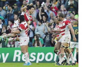 Japanese players celebrate the winning try by Karne Hesketh in their 34-32 upset of the South Africa Springboks at the Rugby World Cup in England. The victory has been called the biggest upset in World Cup history.