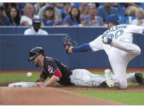 Jason Kipnis, left, of the Indians advances safely to third base in the first inning Monday as Josh Donaldson of the Blue Jays cannot hold onto the ball.
