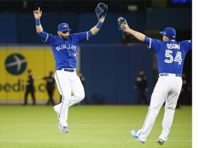 Jose Bautista #19 of the Toronto Blue Jays and Roberto Osuna #54 celebrate a 7-1 win over the Kansas City Royals during game five of the American League Championship Series at Rogers Centre on October 21, 2015 in Toronto, Canada.  (Photo by Tom Szczerbowski/Getty Images)