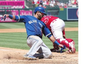 Jose Bautista of the Toronto Blue Jays slides home on a single by Edwin Encarnacion ahead of the throw to catcher Carlos Perez of the Los Angeles Angels of Anaheim in the third inning on Sunday. The Jays won 12-5 to complete a three-game sweep.
