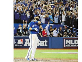 Jose Bautista of the Toronto Blue Jays throws his bat up in the air after he hits a three-run home run in the seventh inning against the Texas Rangers in Game 5 of the American League Division Series at Rogers Centre on Wednesday in Toronto. See more game coverage on B1