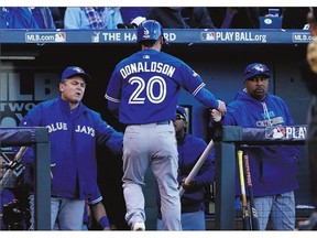 Josh Donaldson of the Toronto Blue Jays is congratulated by manager John Gibbons after scoring in the sixth inning of Saturday's Game 2 of the ALCS in Kansas City. The Jays squandered a 3-0 lead before losing 6-3 to fall behind 2-0 in the series.