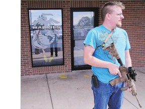 Joshua B. Van Natter stands guard outside a military recruiting centre in Logan, Utah Tuesday. Gun-toting citizens like him are saying they plan to protect recruiters following last week's killing of four Marines and a sailor in Chattanooga, Tenn.