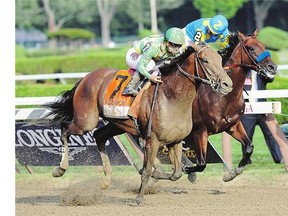 Keen Ice, left, with Javier Castellano, moves past Triple Crown winner American Pharoah, with Victor Espinoza, to win the Travers Stakes at Saratoga Race Course Saturday.