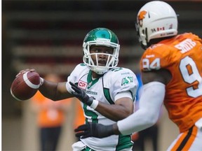 Kevin Glenn prepares to throw a pass under pressure from the Lions’ Khreem Smith