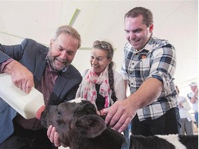 NDP Leader Tom Mulcair, left, his wife Catherine Pinhas Mulcair, and federal NDP candidate of Perth-Wellington Ethan Rabidoux in Brunner, Ont., last week. The NDP leader and fellow party leaders were busy travelling the country in July.