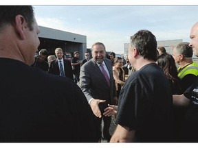 NDP Leader Tom Mulcair shakes hands with aerospace workers Tuesday in Montreal. Mulcair sidestepped questions on a possible coalition at the event.