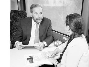 NDP Leader Tom Mulcair and his wife Catherine depart after a campaign stop London, Ont., Wednesday. As part of the party's strategy to attract new voters, it is taking a cautious approach to counter criticisms that it would spend recklessly if elected.