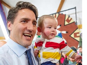 Liberal leader Justin Trudeau holds up a baby during a rally Friday, October 9, 2015 in Yellowknife. THE CANADIAN PRESS/Paul Chiasson
