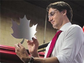 Liberal leader Justin Trudeau holds a maple leaf shape cut out of sheet metal prior to speaking at a campaign stop in Brampton, Sept. 25.