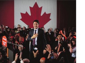 Liberal leader Justin Trudeau puts his hand on his heart as he arrives to Liberal election headquarters in Montreal.