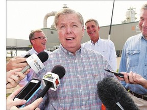 U.S. Sen. Lindsey Graham, centre, speaks while flanked by Premier Brad Wall, left, and Congressman Tom Rice and U.S. Sen. Sheldon Whitehouse, right, before a tour of the Boundary Dam Carbon Capture plant just outside of Estevan on Wednesday.