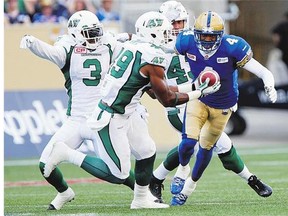 Linebacker Jeff Knox Jr., centre, making an interception Saturday, was a key part of a strong Saskatchewan Roughriders defence against the host Winnipeg Blue Bombers.