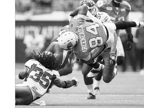 BC Lions' Manny Arceneaux, right, is upended by Saskatchewan Roughriders' Weldon Brown at BC Place last Friday. Brown is out for the rest of the season with a torn pectoral muscle.