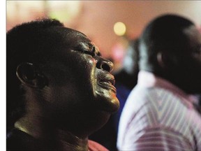 Lisa Doctor joins prays Thursday, down the street from Emanuel AME Church where a white man opened fire Wednesday night in during a prayer meeting inside the historic black church in Charleston, S.C., killing multiple people, including the pastor, in an assault that authorities described as a hate crime.