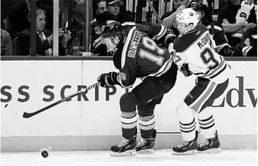 St. Louis Blues' Jay Bouwmeester, left, and Edmonton Oilers' Connor McDavid chase after a puck during NHL action Thursday night in St. Louis. McDavid, the highly touted No. 1 pick in last year's entry draft, had an assist in his NHL debut.