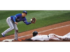 Manny Machado of the Baltimore Orioles steals third base as Munenori Kawasaki of the Toronto Blue Jays waits for the throw during the fourth inning of the Orioles' 6-4 win at Oriole Park at Camden Yards on Thursday in Baltimore.