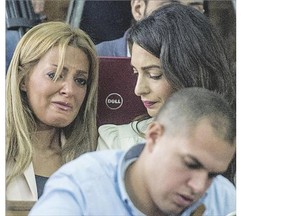 Marwa Fahmy, left, wife of Canadian Al-Jazeera journalist Mohamed Fahmy (unseen), reacts as she sits next to Amal Clooney, the human rights lawyer representing Fahmy, during the trial of her husband and Egyptian Baher Mohamed, accused of supporting the blacklisted Muslim Brotherhood in their coverage.