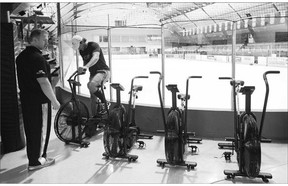 Matt Nichol, left, who co-invented the workout supplement drink BioSteel, works with a player following an on-ice training session at St. Michael's College in Toronto on Aug. 28.