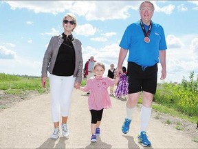 Mayor Don Atchison, right, his wife Mardele and granddaughter Katarina, 4, walk across the finish line at the Mayor's Marathon on Sunday. Atchison did the event to raise awareness and money for the Meewasin trail system.