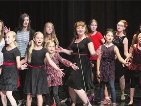 Melissa Nygren, centre, of singing group Rosie And The Riveters performs on stage with youth who attended a one-day singing workshop with the band on Monday. Seventeen children between the ages of seven and 16 participated in the workshop.