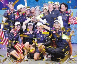 Members of the American team celebrate with the Solheim Cup after beating Europe Sunday in St. Leon-Rot, Germany. The Americans won the Cup for the first time since 2009.