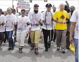 Michael Brown Sr., centre, leads a march in remembrance of his son in Ferguson, Mo., on Sunday.