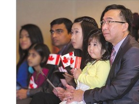 Michael Reyes, left, with his daughters Denise Anne on his lap and Danielle, along with his wife Jennifer and son John David, not shown, at Tuesday's citizenship ceremony at TCU Place. Michael and his family are originally from Philippines.