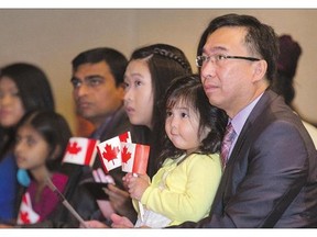 Michael Reyes with daughters Denise Anne, on his lap, and Dannielle, who all hail from the Philippines, are inducted as Canadian citizens on Sept. 15. In many parts of the country where immigrants are concentrated, such as Ontario and B.C., the impact of the newcomer vote could have a big impact on the outcome of the election.