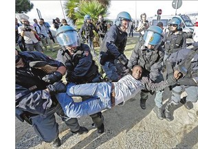 A migrant is removed by Italian police at the Franco-Italian border Tuesday. Some 150 migrants, principally from Eritrea and Sudan, have been trying since last Friday to cross the border from Italy but have been blocked by French and Italian police.