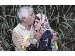 A migrant woman cries as she is embraced by a relative Wednesday. The pair arrived on the shores of the Greek island of Lesbos after crossing the Aegean Sea from Turkey on a dinghy.