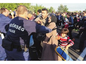 Migrants are pushed back down the road by police on the M5 highway near Roszke village at the Hungarian-Serbian border on Sunday.