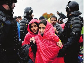 Migrants wait in the rain at the Trnovec border crossing as restrictions on movements through have produced bottlenecks on Croatia's borders. Slovenian authorities closed the border after reaching their daily quota, leaving over 1,000 migrants stranded.
